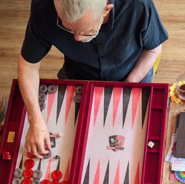A backgammon game in play on a red board
